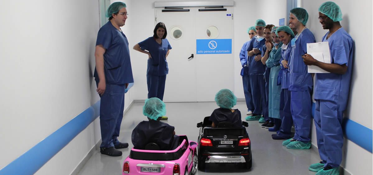 Dos pacientes pediátricos llegando al área quirúrgica del hospital en los coches teledirigidos